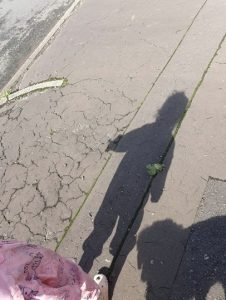 A shadow of a child on a cracked pavement